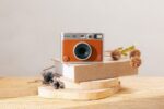 We_tested_Fujifilms_Instax_Mini_Evo_here_our_take-Camera_sitting_on_beige_book-Credit_Elvis_Chung-HERO.renditionimage.900.600